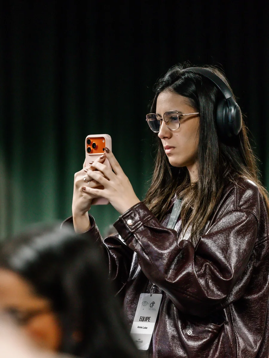 Annie Lemos de fone e crachá de equipe nos bastidores